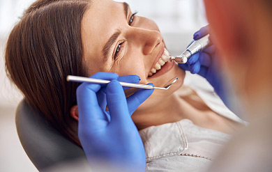 Tratamientos honestos y personalizados movil Dentista examinando la boca de un paciente en Centro Dental Garibai